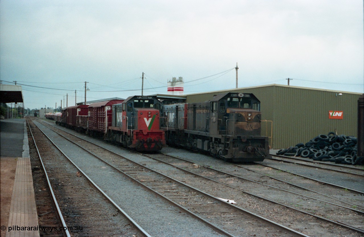 160-17
Shepparton, station yard overview looking south towards Melbourne from platform, stabled V/Line broad gauge T class locomotives T 371 Clyde Engineering EMD model G8B serial 64-326, T 385 serial 64-340 still in Victorian Railways blue and yellow and T 393 serial 65-423 behind T 385, T 371 is on a stabled down Shepparton goods train in No.3 Rd, while T 385 and T 393 worked the down Shepparton fuel train and is stabled on No.4 Rd, goods shed behind and pile of traction tyres at right.
Keywords: T-class;T371;Clyde-Engineering-Granville-NSW;EMD;G8B;64-326;