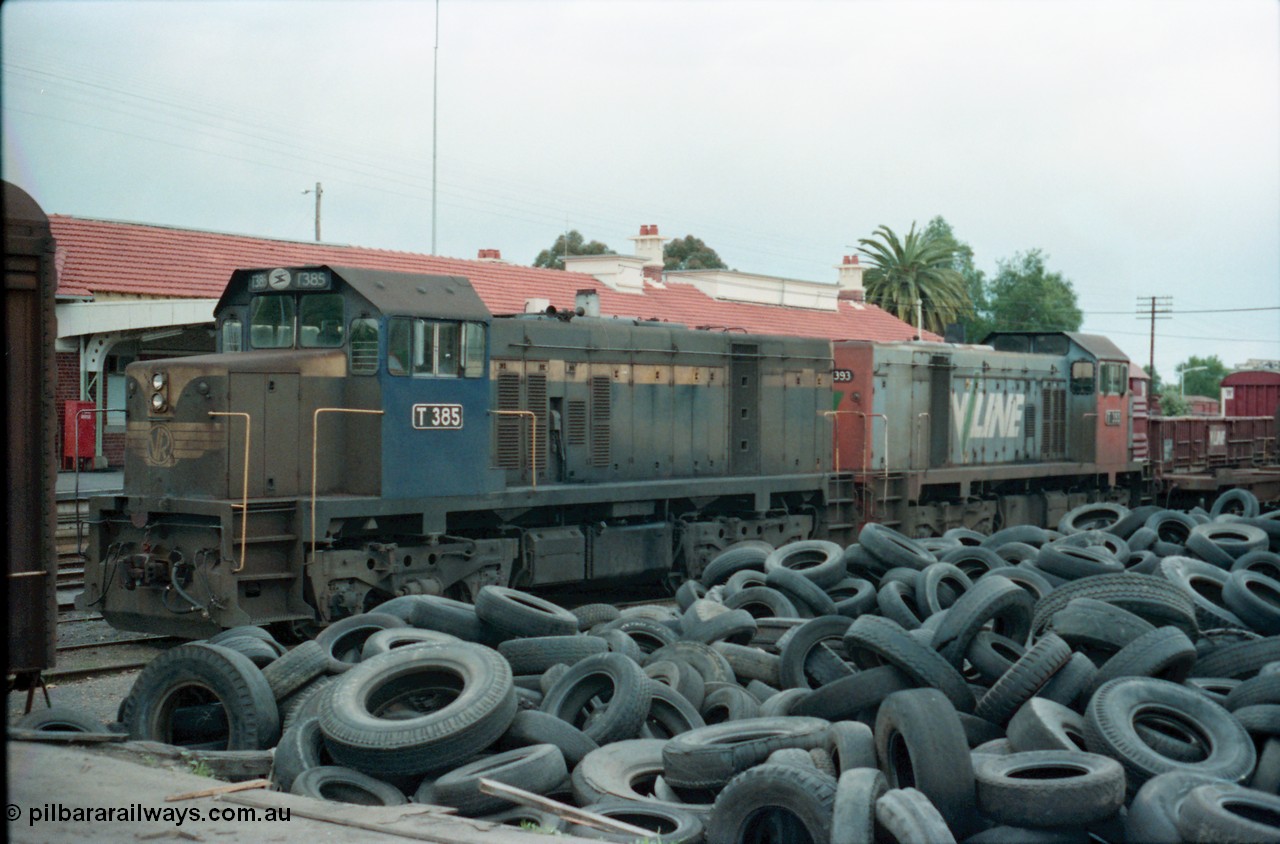 160-25
Shepparton, stabled V/Line broad gauge T class locomotives T 385 Clyde Engineering EMD model G8B serial 64-340 still in Victorian Railways blue and yellow livery and T 393 serial 65-423 off the down Shepparton fuel train, looking from the good loading platform with a mountain of 2nd hand tyres piled up.
Keywords: T-class;T385;Clyde-Engineering-Granville-NSW;EMD;G8B;64-340;