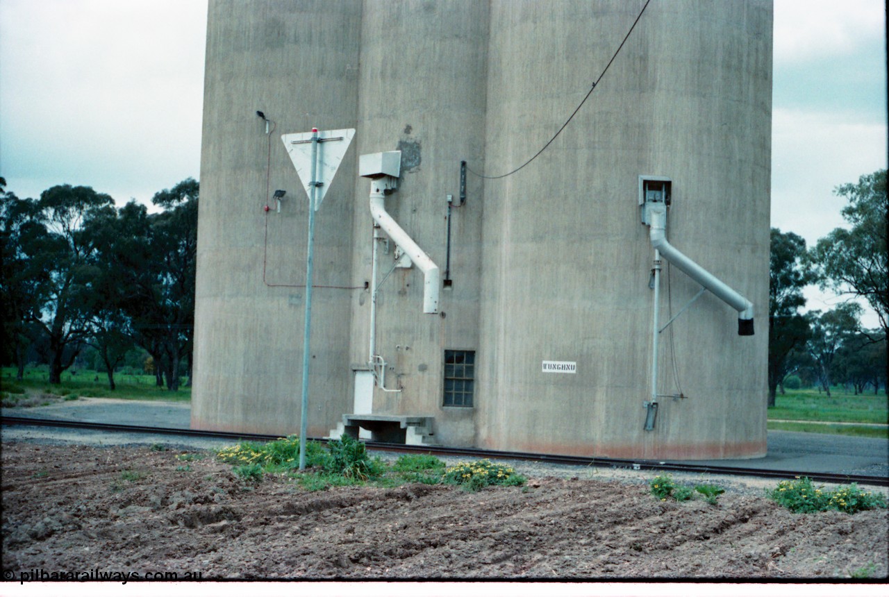 160-35
Wunghnu, track view from former station building site looking across tracks to Williamstown style silo complex, train load-out spouts, rear of location sign.
