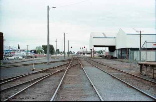 160-27
Shepparton, yard overview looking north down No.2 Rd which becomes the mainline to Tocumwal and Cobram, No.3, 4 and 5 roads at left, former Engine Track on the right to service J. Murray More Pty Ltd or Tubemakers unloading gantry, searchlight signal post protecting up and down movements, station building and platform behind on the right.
