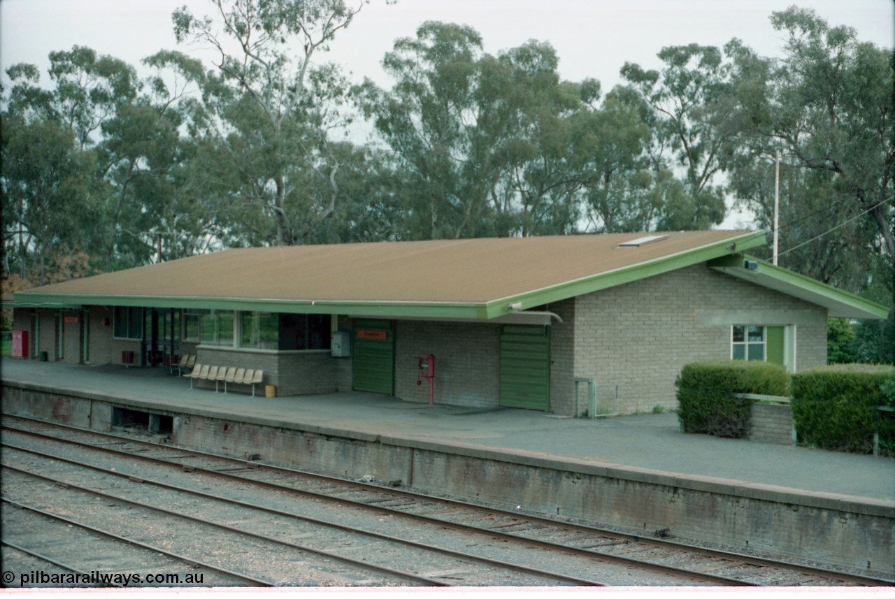 161-00
Numurkah, station building overview of modern brick structure, signal bay opening and weigh scales are reminders of an older era, taken from footbridge.
