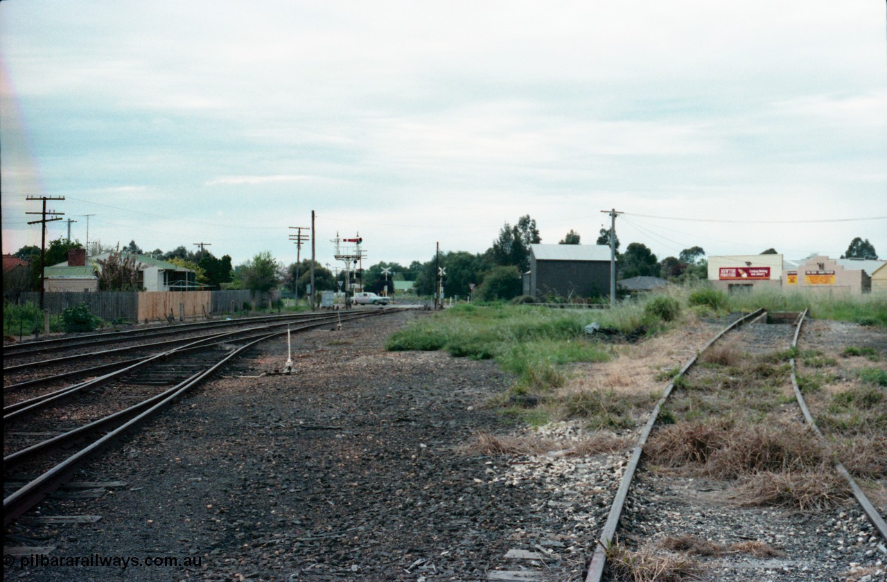 161-06
Numurkah, yard view looking north towards Strathmerton, semaphore signal post 4 still has the Strathmerton line semaphore but the Picola line semaphore has been removed, Picola Junction is just over the grade crossing around the curve, track at right is heading across the ash pit to the turntable, the grass in the middle between the yard and turntable road used to have two sidings in there.
