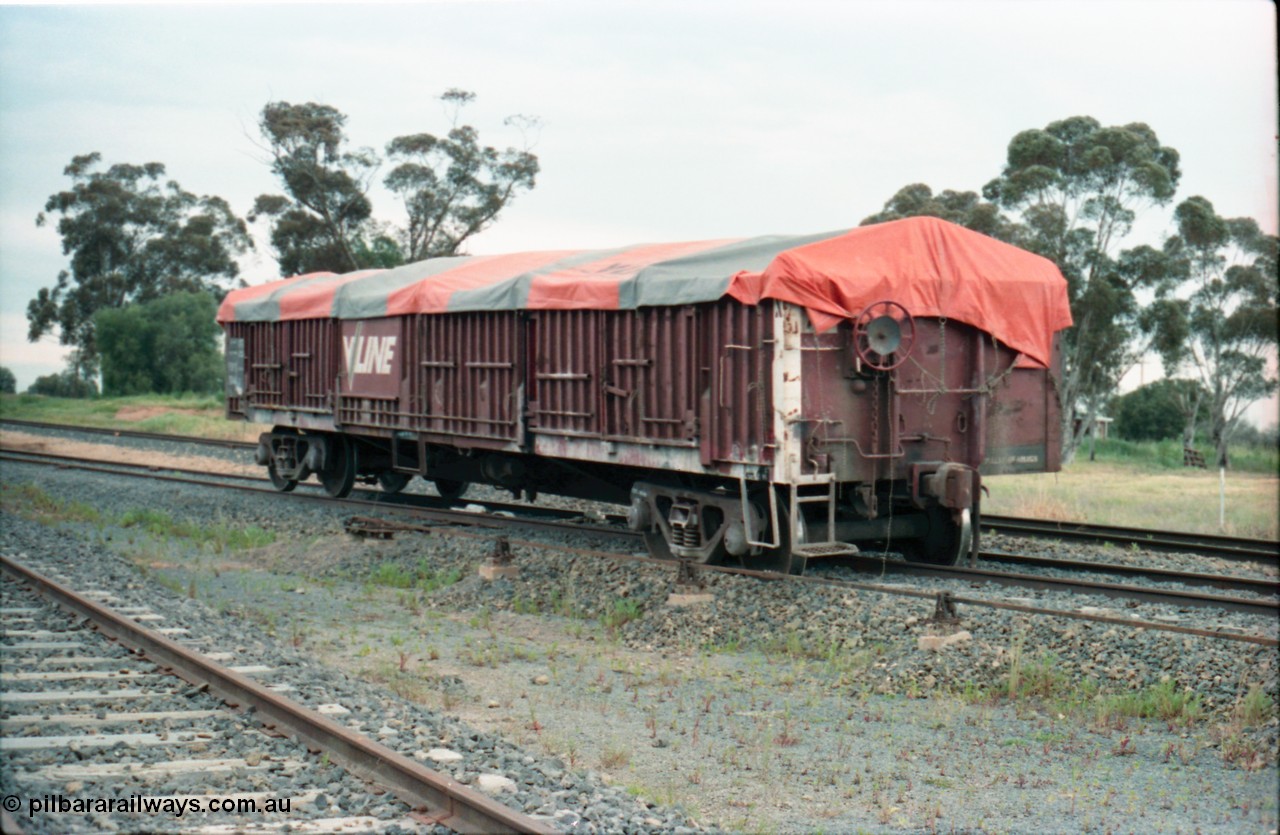 161-13
Katunga, north end of yard view with derailed V/Line broad gauge VOFX type bogie open waggon VOFX 1044 covered with tarpaulin and loaded with super phosphate, hand brake end, waggon started life built by Victorian Railways Bendigo Workshops in May 1975 as an ELX type, in 1978 to VOCX and in the 1980s to VOFX, point rodding for derail and derail visible under middle of waggon, mainline behind waggon.
Keywords: VOFX-type;VOFX1044;Victorian-Railways-Bendigo-WS;ELX-type;