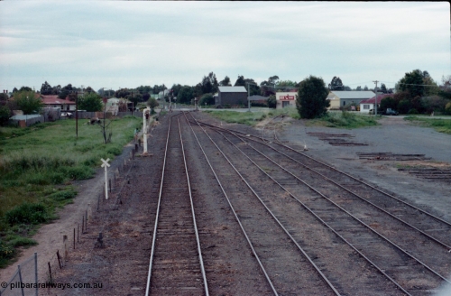 161-02
Numurkah, station yard overview looking north towards Picola Junction, steam era stand pipe remains on No.1 Rd, semaphore signal post remains with Picola Line doll removed, the down starting semaphore for the Strathmerton line is visible in the trees, track to turntable and ash pit at right.
