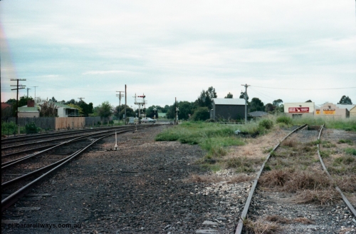 161-06
Numurkah, yard view looking north towards Strathmerton, semaphore signal post 4 still has the Strathmerton line semaphore but the Picola line semaphore has been removed, Picola Junction is just over the grade crossing around the curve, track at right is heading across the ash pit to the turntable, the grass in the middle between the yard and turntable road used to have two sidings in there.
