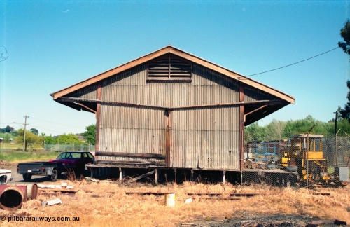 162-1-02
Healesville, view of goods shed, eastern side elevation and loading platform, fenced off compound with track machines, standard Victorian Railways 20 ft goods shed.
