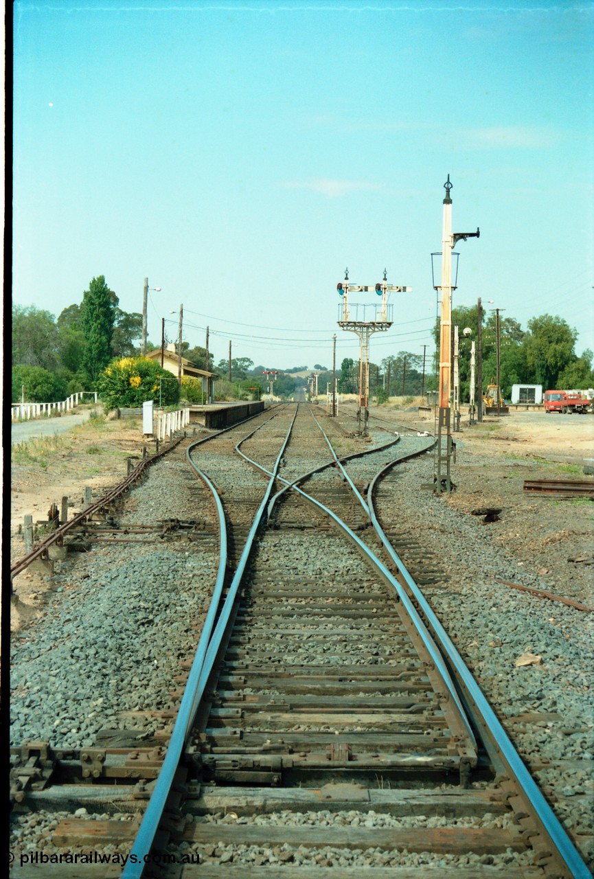 163-18
Avenal station yard overview looking south down No.2 Road from the mainline points, interlocking, rodding and signal wires, No.1 Road on the left with station building and platform, semaphore signal post 10 still active for down trains, while No.3 Road has been retained, No.4 and 5 Roads and Sidings B have been removed, disc signal posts 11 and 9 have been stripped while 12 remains for No.3 Road.
