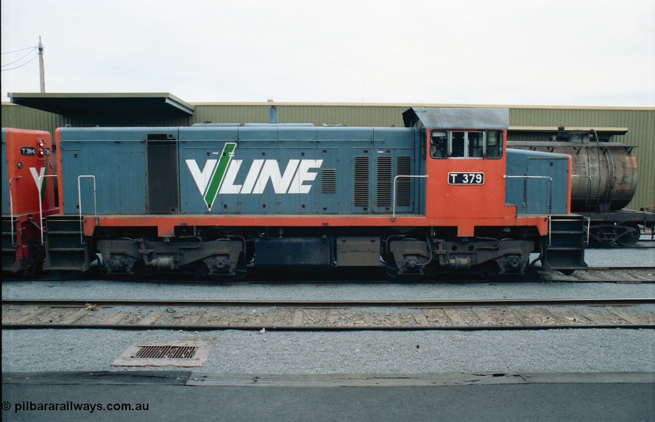 163-23
Shepparton station view from platform with stabled V/Line broad gauge T class locomotive T 379 Clyde Engineering EMD model G8B serial 64-334, goods shed behind loco, side view.
Keywords: T-class;T379;Clyde-Engineering-Granville-NSW;EMD;G8B;64-334;