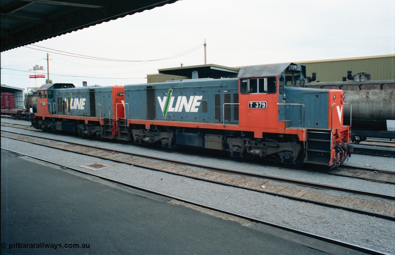 163-24
Shepparton station view from platform with stabled V/Line broad gauge T class locomotives T 379 Clyde Engineering EMD model G8B serial 64-334 and T 384 serial 64-339 next to the fuel train they operated the night before, goods shed is behind the consist, Freightgate and cement silos in the background.
Keywords: T-class;T379;Clyde-Engineering-Granville-NSW;EMD;G8B;64-334;