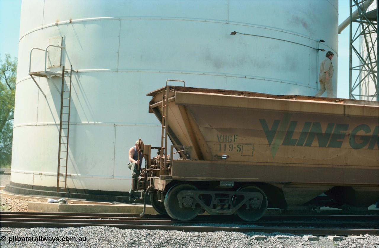 164-16
Murchison East, broad gauge V/Line Grain VHGF type bogie grain waggon VHGF 119, built as a GJX type by Steelweld Victoria in January 1969, showing signs of being recoded from VHGY has a GEB worker operating the lever action handbrake as the rake is moved down the road under its' own weight, while another worker closes the roof hatches in front of the Ascom silo complex.
Keywords: VHGF-type;VHGF119;Steelweld-Vic;GJX-type;