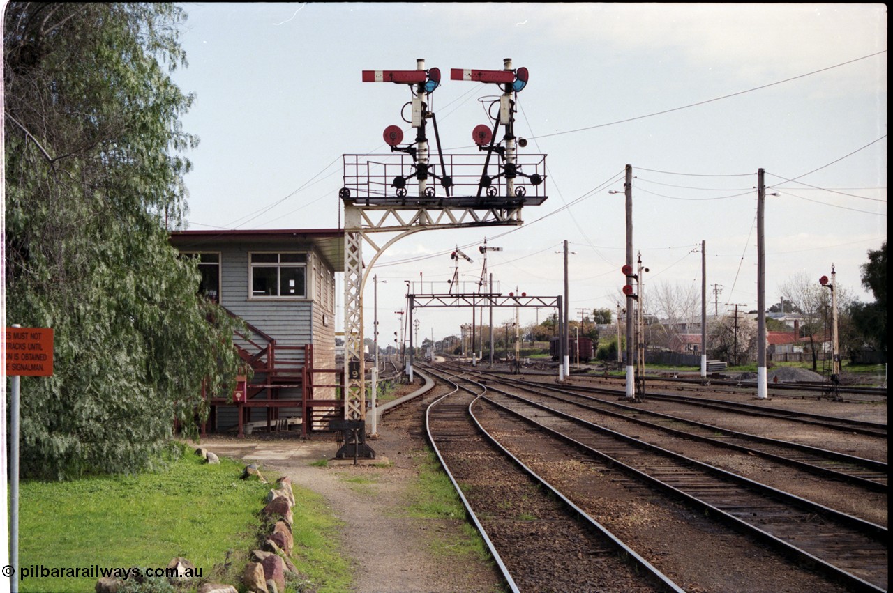 165-00
Wodonga, yard overview looking south from station platform past signal box A, steel lattice double doll semaphore signal post 19, semaphore signal 10B pulled off for down passenger train, semaphore signal post 10, double disc signal posts 12 and 17 with disc signal post 16 on the right, the louvre vans in the background are on the former coal stage track.
