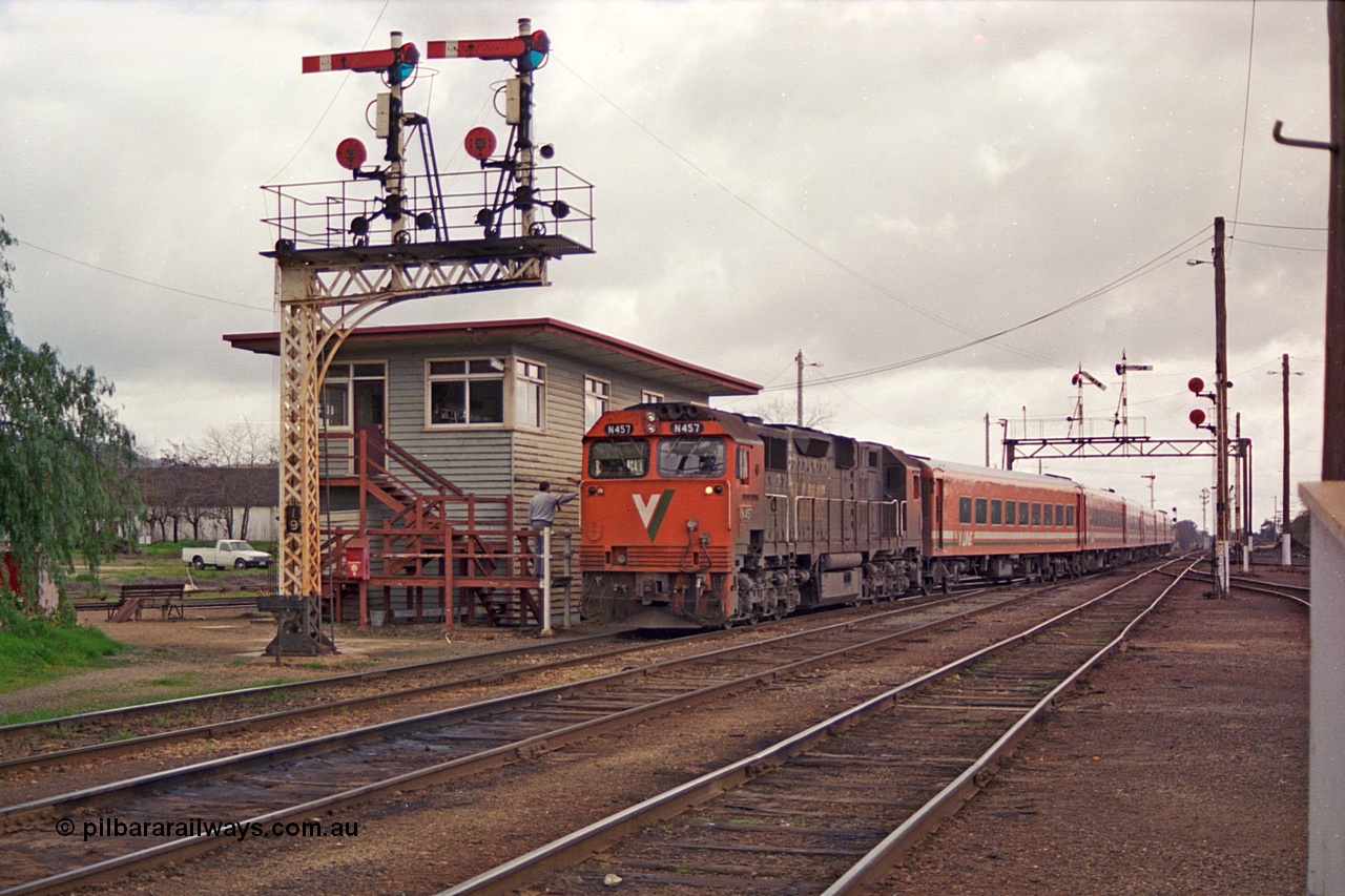 166-02
Wodonga, V/Line broad gauge N class N 457 'City of Mildura' Clyde Engineering EMD model JT22HC-2 serial 85-1225 surrenders the electric staff to the signaller at A box with the down Albury passenger train as it runs into No.1 Rd, framed between semaphore signal post 19 and semaphore signal post 10B pulled off on the gantry.
Keywords: N-class;N457;Clyde-Engineering-Somerton-Victoria;EMD;JT22HC-2;85-1225;