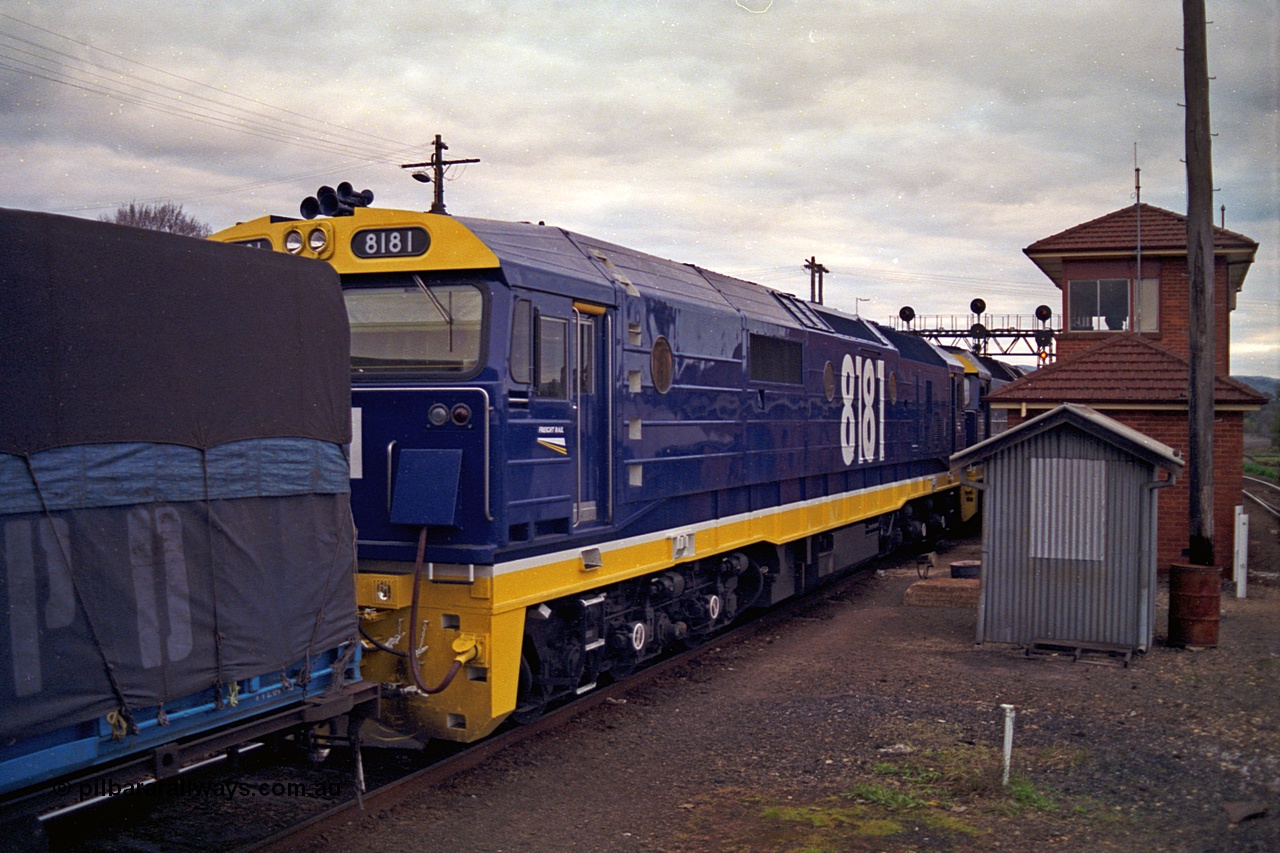 166-09
Albury South Signal Box, brand new NSWSRA 81 class locomotive 8181 Clyde Engineering EMD model JT26C-2SS serial 91-1278 in Freight Rail Stealth livery arrives as second unit on a Melbourne bound goods train, the two 81 class units will be swapped out for V/Line motive power, the broad gauge platform track can been seen on the far right behind the signal box.
Keywords: 81-class;8181;Clyde-Engineering-Kelso-NSW;EMD;JT26C-2SS;91-1278;