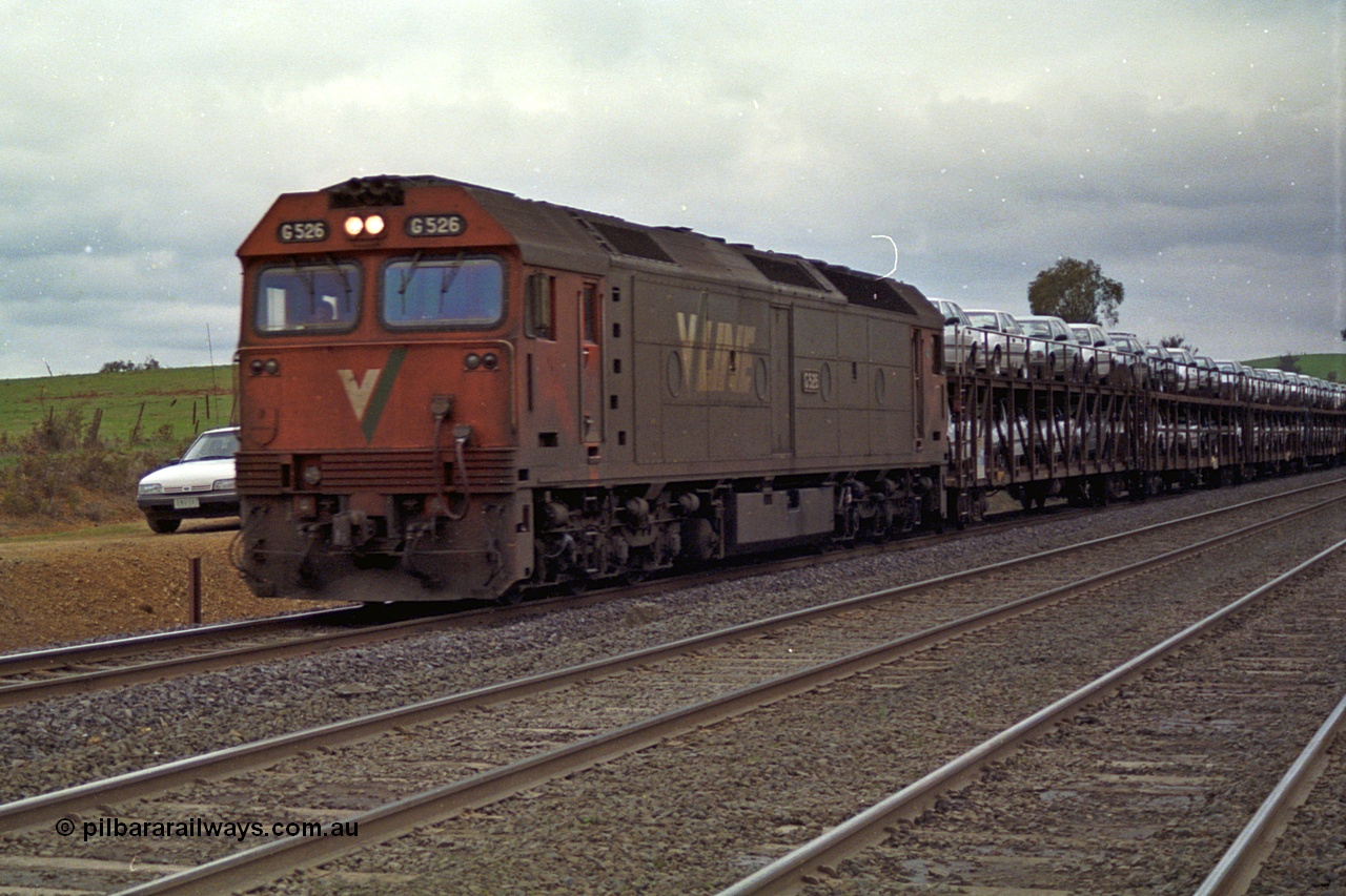 166-18
Wandong, down V/Line standard gauge car or Ford train behind G class G 526 Clyde Engineering EMD model JT26C-2SS serial 88-1256 with a rake of loaded motor car transport waggons conveying Ford motor cars from their Somerton plant to NSW, at Mathiesons Siding - O'Gradys Road grade crossing.
Keywords: G-class;G526;Clyde-Engineering-Somerton-Victoria;EMD;JT26C-2SS;88-1256;