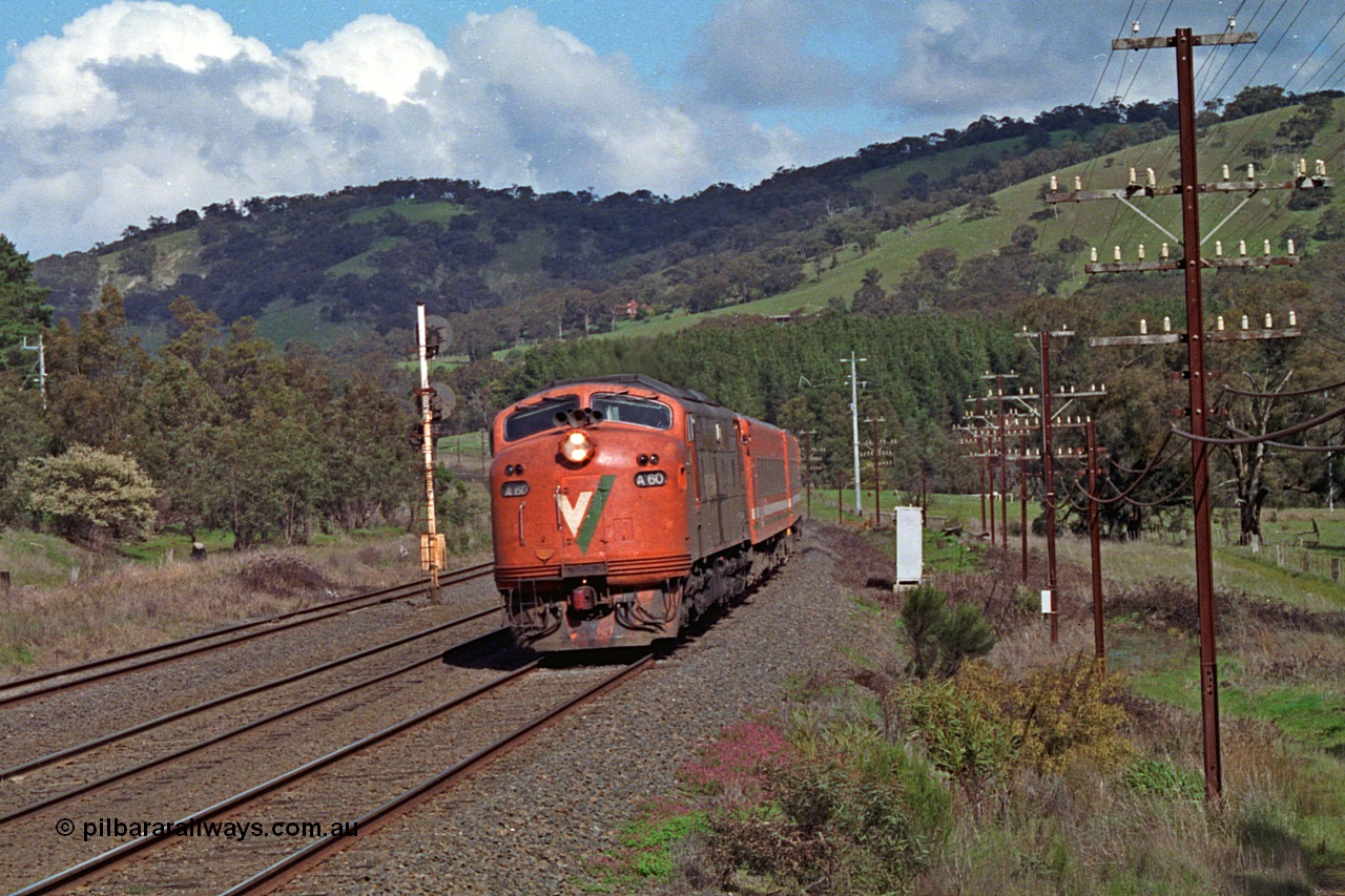 166-21
Kilmore East, down V/Line broad gauge passenger train powered by Bulldog rebuild A class leader A 60 Clyde Engineering EMD model AAT22C-2R serial 84-1184 rebuilt from B class B 60 Clyde Engineering EMD model ML2 serial ML2-1 with N set blasts upgrade, the signal post on the standard gauge line is the Kilmore East home for the broad gauge crossing into the Apex Quarry Siding and numbered KME/6.
Keywords: A-class;A60;Clyde-Engineering-Rosewater-SA;EMD;AAT22C-2R;84-1184;rebuild;bulldog;