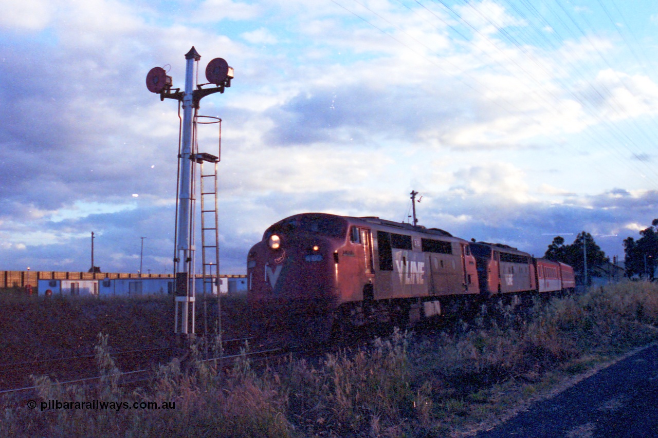 167-12
Wallan, broad gauge V/Line A class A 60 'Sir Harold Clapp' Clyde Engineering EMD model AAT22C-2R serial 84-1184 rebuilt from B class B 60 Clyde Engineering EMD model ML2 serial ML2-1 leads non-rebuilt B class B 76 with the Seymour bound down passenger consisting of the 'scratch set' past twin disc signal post 15 which is for setting back moves, gang camp and sound proofing wall in the background.
Keywords: A-class;A60;Clyde-Engineering-Rosewater-SA;EMD;AAT22C-2R;84-1184;rebuild;bulldog;