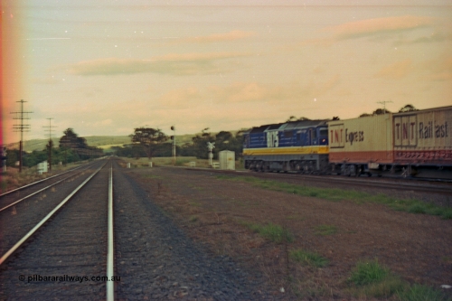 167-10
Wallan Loop, north end, Boundary Rd crossing, standard gauge NSWSRA 81 class 8175 Clyde Engineering EMD model JT26C-2SS serial 85-1094 in new Freight Rail 'Stealth' livery leads its train north across Boundary Road (out of focus), broad gauge tracks on the left.
Keywords: 81-class;8175;Clyde-Engineering-Kelso-NSW;EMD;JT26C-2SS;85-1094;