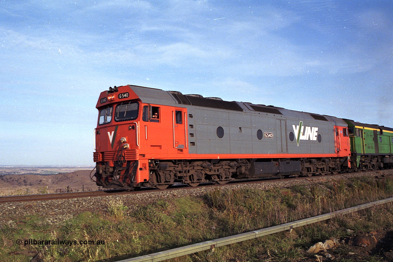 168-04
Bank Box Loop, down V/Line broad gauge goods train to Adelaide behind G class G 540 Clyde Engineering EMD model JT26C-2SS serial 89-1273 and Australian National 700 class 704 AE Goodwin ALCo model DL500G serial G6059-2 take the mainline to cross an up passenger train.
Keywords: G-class;G540;Clyde-Engineering-Somerton-Victoria;EMD;JT26C-2SS;89-1273;