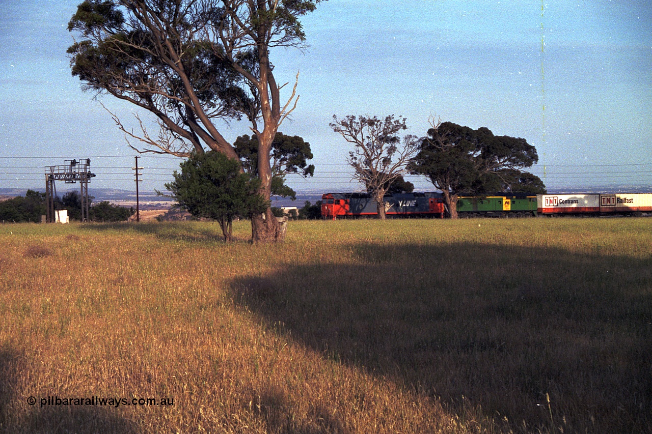 168-05
Bank Box Loop, down V/Line broad gauge goods train to Adelaide behind G class G 540 Clyde Engineering EMD model JT26C-2SS serial 89-1273 and Australian National 700 class 704 AE Goodwin ALCo model DL500G serial G6059-2 stand at the down end of the crossing loop on the mainline awaiting a cross with an up passenger train.
Keywords: G-class;G540;Clyde-Engineering-Somerton-Victoria;EMD;JT26C-2SS;89-1273;