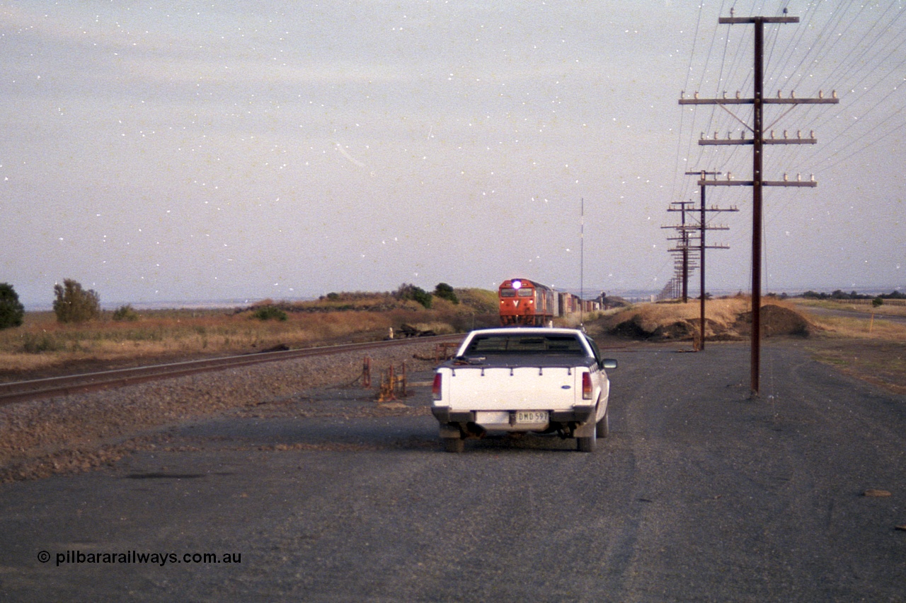 168-12
Bank Box Loop, climbing the grade in the distance looking towards Bacchus Marsh are a pair of V/Line G class units with an Adelaide bound freighter.
