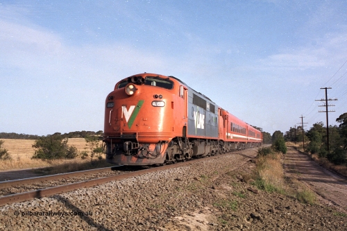 168-02
Bank Box Loop, down broad gauge V/Line passenger service powered by rebuilt A class Bulldog A 62 Clyde Engineering EMD model AAT22C-2R serial 84-1183 rebuilt from B class B 62 Clyde Engineering EMD model ML2 serial ML2-3 with N set and D van at Ironbark Road grade crossing.
Keywords: A-class;A62;Clyde-Engineering-Rosewater-SA;EMD;AAT22C-2R;84-1183;rebuild;bulldog;