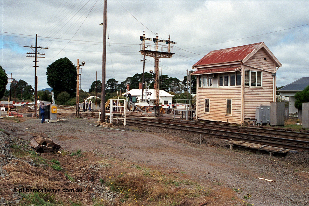 171-02
Ballarat, Linton Junction signal box Gillies St, work site view, interlocked gates being replaced by boom barriers, view of signal box, triple doll semaphore signal Post 20, Timken's Siding disc signal Post 21, staff exchange platform and auto exchange apparatus cover open, track view.
