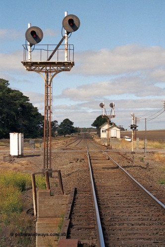 171-09
Trawalla station yard overview, looking towards Melbourne down main line, Up Home searchlight signal Post 6, left hand post Home from Main Line to No. 2A via No. 2 Road to Post 3 and the right hand post Home from Main Line to No. 1 Road to Post 3. Waterloo Road grade crossing, points and rodding, searchlight signal Post 5 facing away, station building and signal box in the distance.
