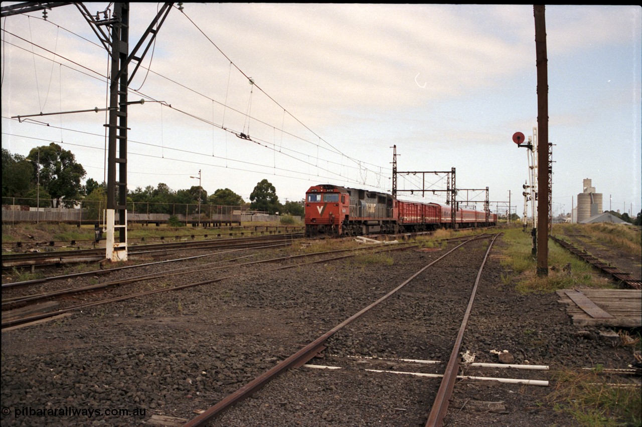 172-05
Sunshine, broad gauge V/Line N class N 470 'City of Wangaratta' Clyde Engineering EMD model JT22HC-2 serial 86-1199 leads a down passenger service with the unusual consist of 2 D vans, 4 car N set and another D van, the former Sunshine yard ends where I'm standing with the access to the Newport - Sunshine Loop Line running down the right hand side.
Keywords: N-class;N470;Clyde-Engineering-Somerton-Victoria;EMD;JT22HC-2;86-1199;