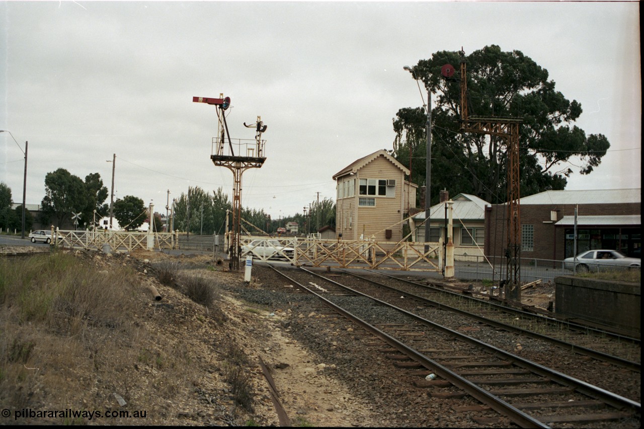 172-20
Ballarat East signal box, track view looking west across Humffray Street interlocked gates, semaphore signal post 5 and disc signal post 5A frame the gates, the former passenger platform is visible on the right.
