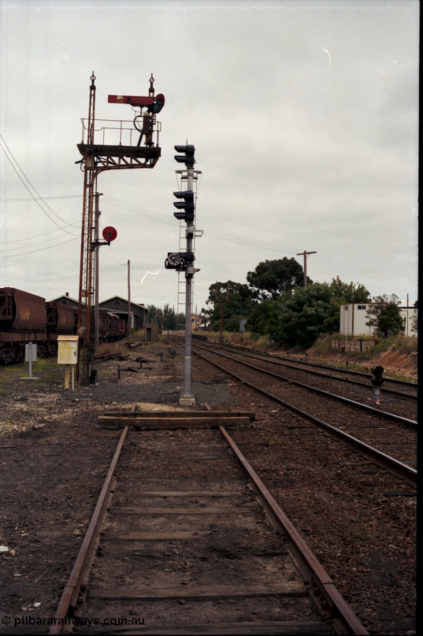 172-23
Ballarat East, semaphore signal post 3, looking west towards Ballarat, new electric colour light signal installed, baulks on the end of the former Eureka line, Ballarat East loco depot on the left, electric colour dwarf signal between mainlines.
