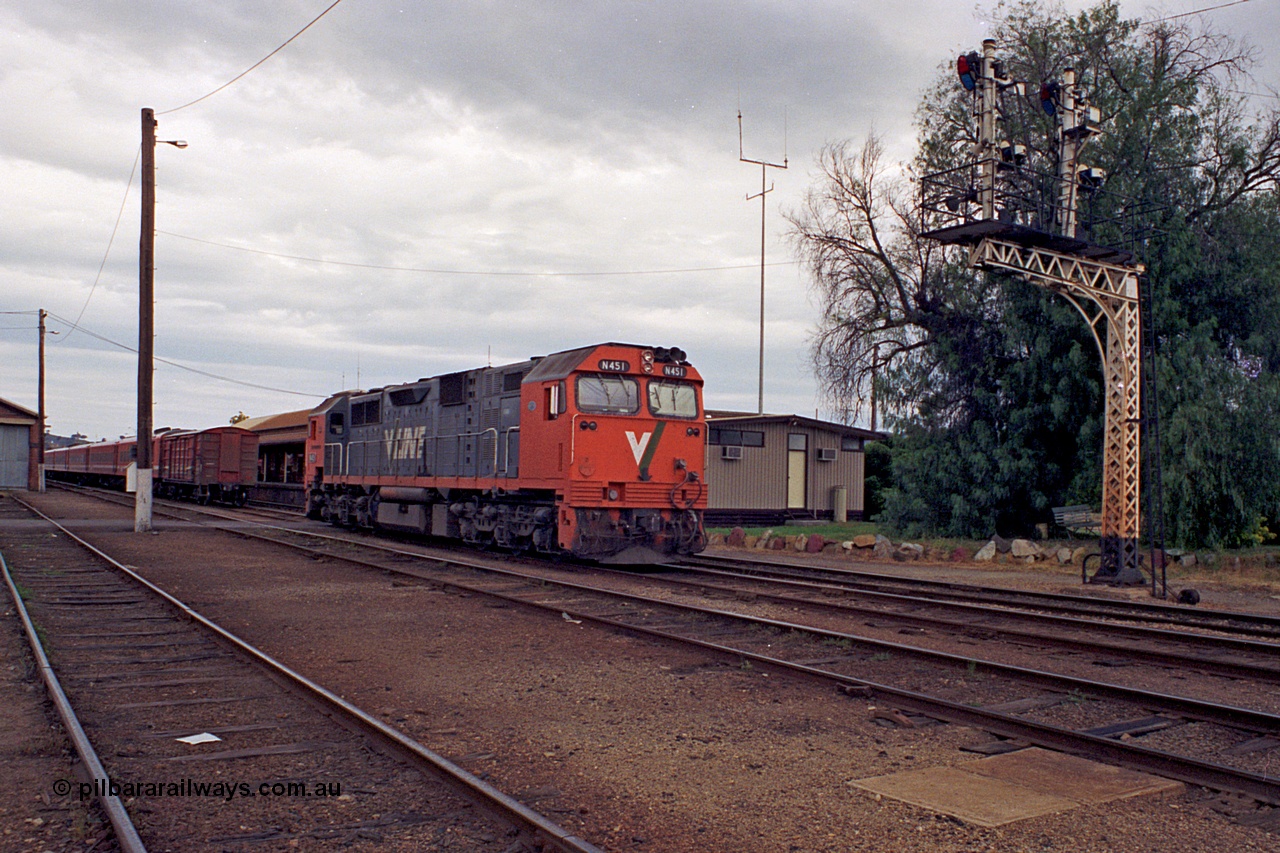 174-01
Wodonga, station yard view, goods shed at far left, stabled passenger train carriage set, V/Line broad gauge N class locomotive leader N 451 'City of Portland' Clyde Engineering EMD model JT22HC-2 serial 85-1219 sits in the yard, impressive lattice mast semaphore signal post 19 stands sentinel.
Keywords: N-class;N451;Clyde-Engineering-Somerton-Victoria;EMD;JT22HC-2;85-1219;