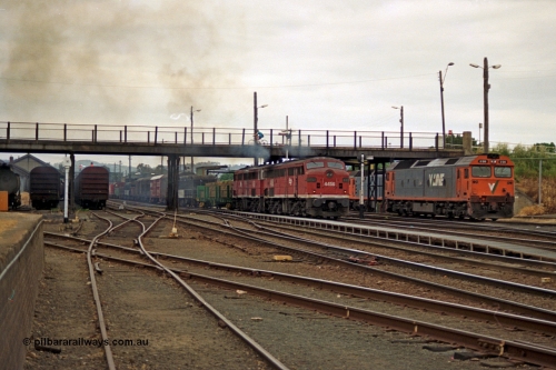 174-22
Albury, yard view from station dock area, NSWSRA standard gauge Red Terror liveried pair of 44 class 4456 AE Goodwin ALCo model DL500B serial 83746 and 4458 AE Goodwin ALCo model DL500B serial 83748 shunt the north with a Melbourne bound goods train, the broad gauge diamond is visible cutting across to the left.
Keywords: 44-class;4456;AE-Goodwin;ALCo;DL500B;83746;