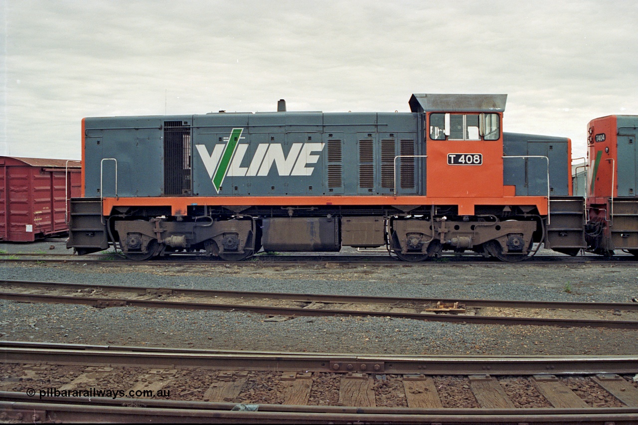 175-03
Shepparton, yard view with V/Line broad gauge T class locomotive T 408 Clyde Engineering EMD model G18B serial 68-624, side view, grounded former B van at left.
Keywords: T-class;T408;Clyde-Engineering-Granville-NSW;EMD;G18B;68-624;