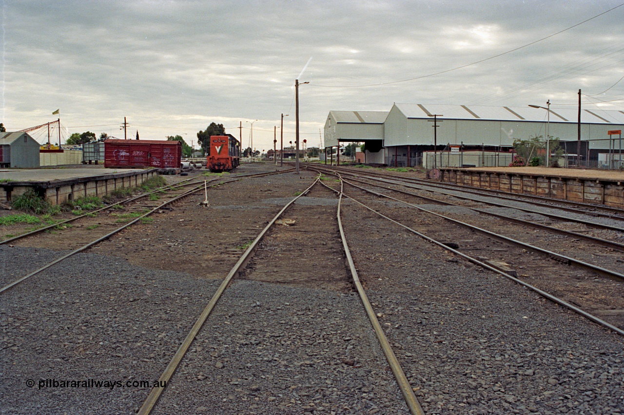 175-07
Shepparton station yard overview looking north from No.4 Road, goods loading platform, grounded B van (was B 325), No.5 Rd and stabled V/Line broad gauge T classes on the left, Tubemakers awning and warehouse with station platform on the right.
Keywords: B-type;B325;fixed-wheel-waggon;