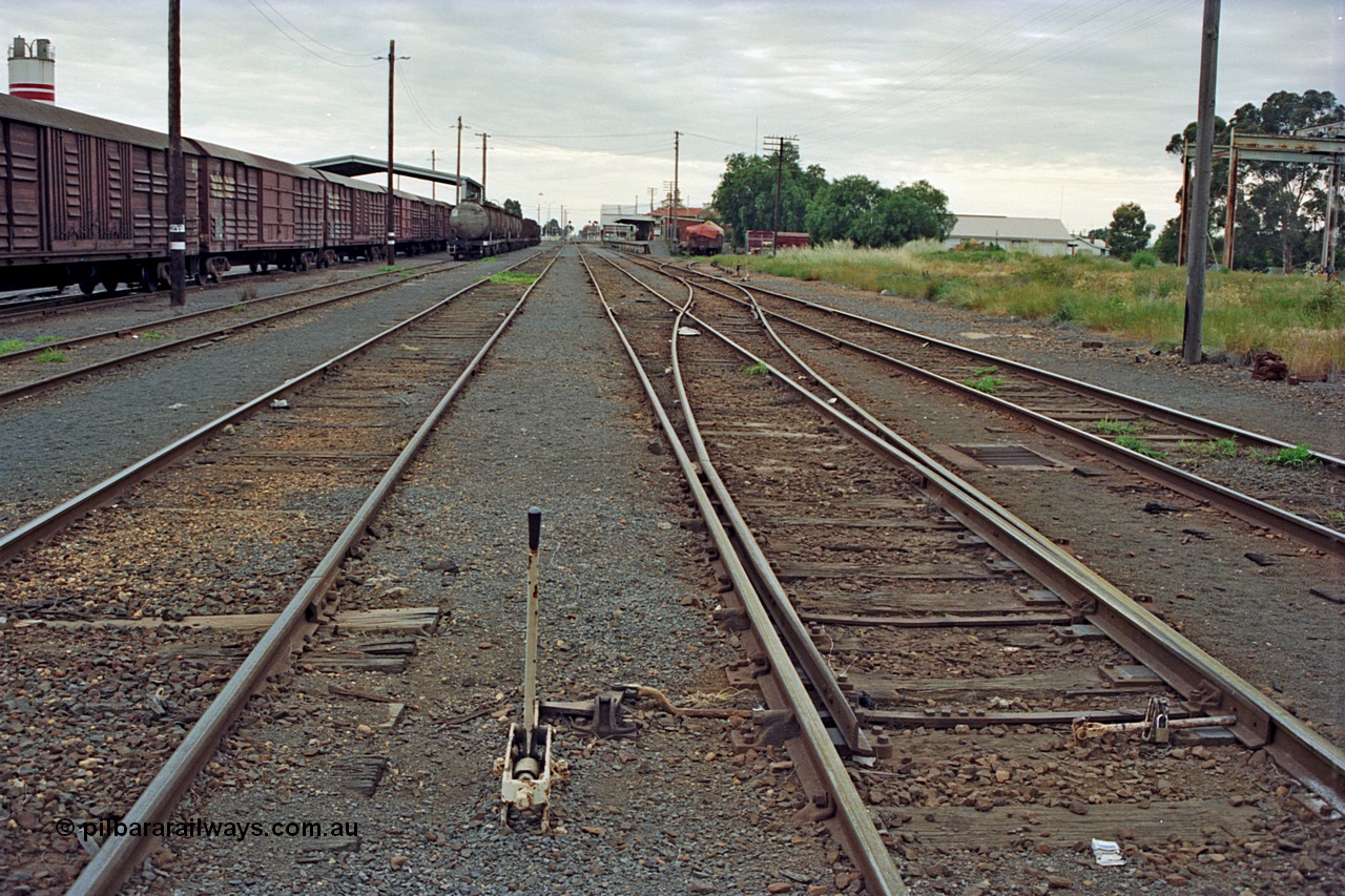 175-09
Shepparton station yard overview looking north, points and lever for No.2 to No.1 Rd cross-over which leads to the former Car Dock, now train examiner's siding, stabled goods and fuel trains on the left with the Freight Gate canopy, station building on the far right beyond examiner's siding.
