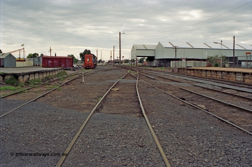 175-07
Shepparton station yard overview looking north from No.4 Road, goods loading platform, grounded B van (was B 325), No.5 Rd and stabled V/Line broad gauge T classes on the left, J. Murray More Pty Ltd or Tubemakers awning which housed a 5 tonne gantry crane  for unloading steel delivered by rail, and warehouse with station platform on the right.
Keywords: B-type;B325;fixed-wheel-waggon;