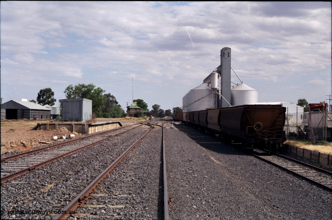 176-04
Yarrawonga station yard overview, looking south, Grain Elevators Board H style horizontal storage bunker at left, goods shed and platform, station building in the distance, V/Line Grain broad gauge VHGF type bogie grain waggons, Grain Elevators Board Ascom style sub-terminal silo complex, with gravitational loading road at right.
Keywords: VHGF-type;
