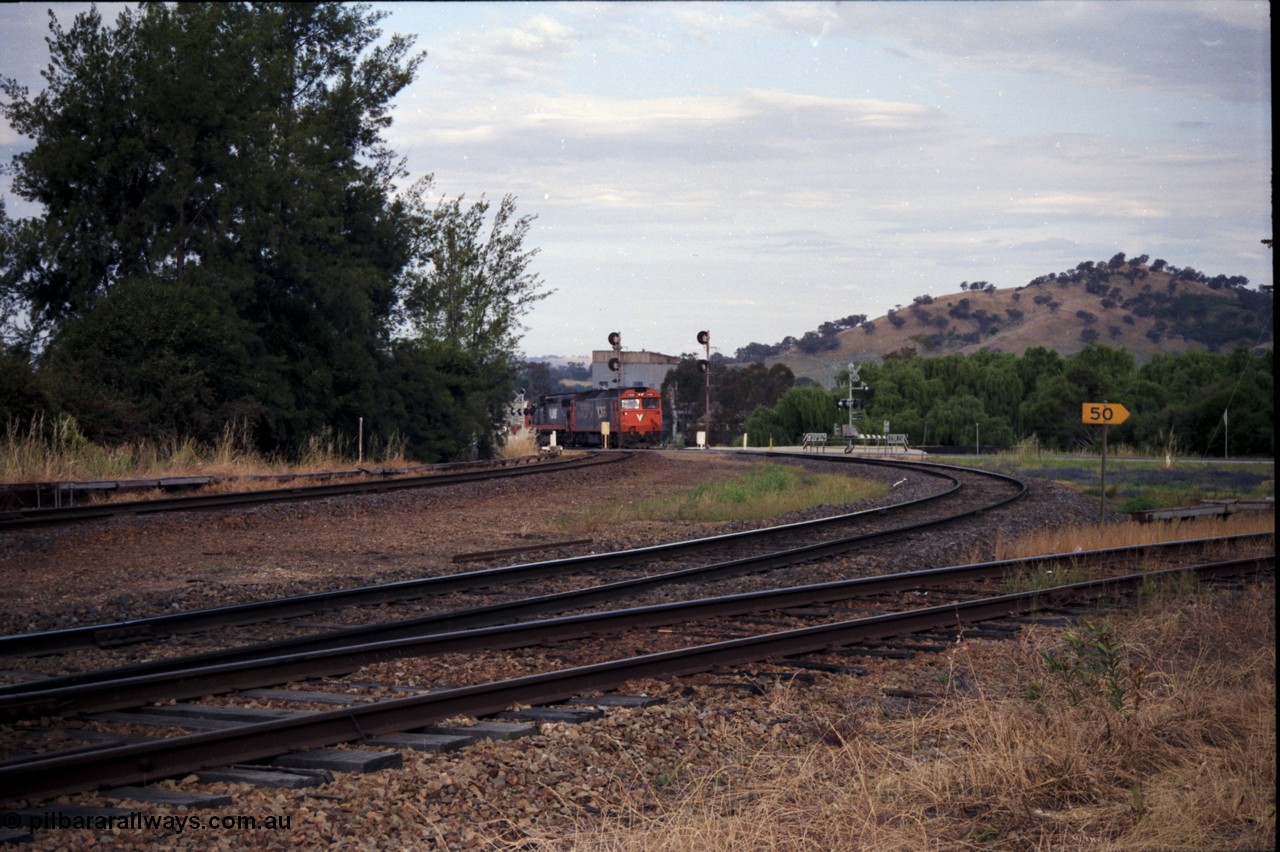 176-08
Wodonga, V/Line standard gauge up goods train passing the Wodonga Coal Sidings behind a G and C class combination, broad gauge track on the left, and the former broad gauge line to Bandiana and Cudgewa curving around to the right.
