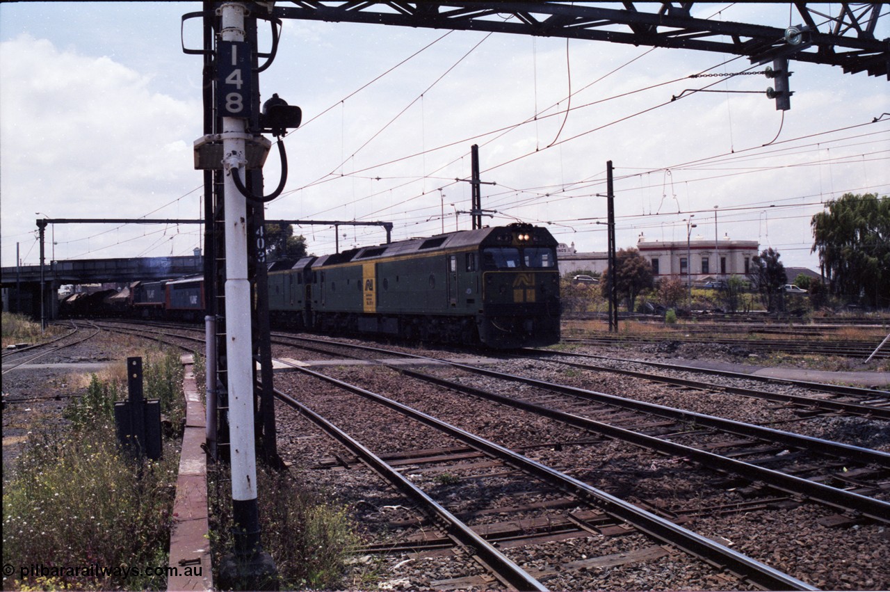 177-14
Newport, looking towards Melbourne, V/Line broad gauge down goods train 9169 creeps under the Melbourne Road overpass behind a pair of Australian National BL class locomotives BL 27 Clyde Engineering EMD model JT26C-2SS serial 83-1011 and class leader BL 26 'Bob Hawke' serial 83-1010, with a V/Line S and X class rounding out the motive power.
Keywords: BL-class;BL27;Clyde-Engineering-Rosewater-SA;EMD;JT26C-2SS;88-1011;