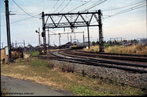 177-11
Newport, track view looking at Geelong - Werribee line, Newport Railway Workshops in the background, an up Werribee 3 car Comeng electric train is rounding the curve in 'The Met' livery.

