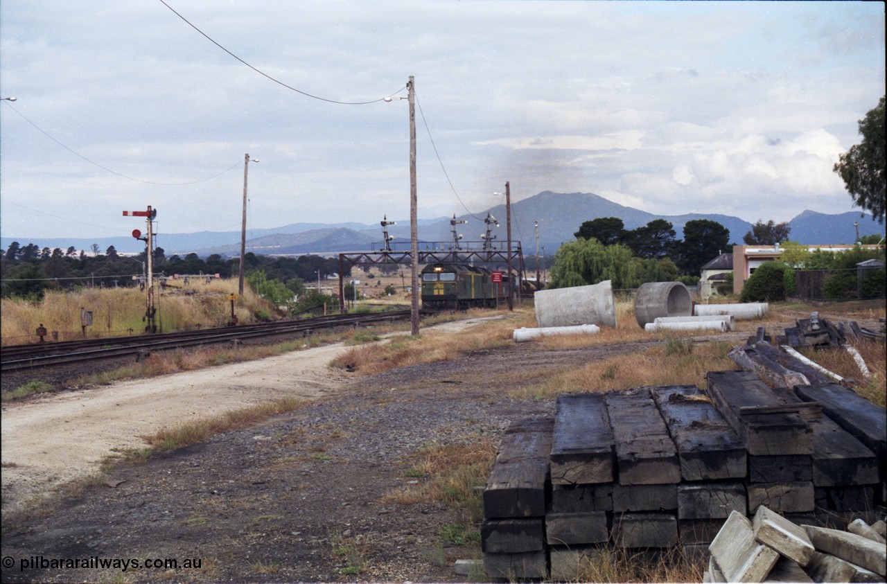 178-15
Ararat, track view looking east as V/Line broad gauge goods train 9169 to Adelaide arrives off the Portland line under the signal gantry with semaphore signal post 4 pulled off behind Australian National BL class locomotives BL 27 Clyde Engineering EMD model JT26C-2SS serial 83-1011 and class leader BL 26 'Bob Hawke' serial 83-1010 and V/Line S class S 313 'Alfred Deakin' Clyde Engineering EMD model A7 serial 61-230 and X class X 53 Clyde Engineering EMD model G26C serial 75-800, semaphore signal post 7 is for the Avoca line, which can be seen curving away around to the left, taken from the former Works and Cattle Sidings area.
