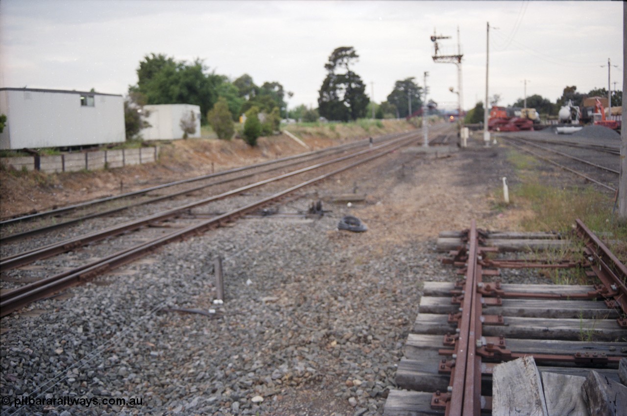 178-22
Ballarat East, track view looking towards Warrenheip with a down goods train on approach, the shot if off focus but the area is being re-signalled from mechanical to electric, with a new set of points to go in and a new electric light signal to replace the mechanical post No.3, Ballarat East loco depot is on the right.
