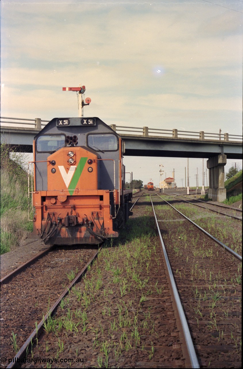 179-19
Gheringhap, station yard overview looking east from the Ballarat line and Siding C, the line to Maroona is on the right, in the back ground semaphore signal post 4 is pulled of for down goods train 9169 to depart, V/Line broad gauge X class locomotive X 51 Clyde Engineering EMD model G26C serial 75-798 is awaiting light engines from Geelong to come and retrieve it.
Keywords: X-class;X51;Clyde-Engineering-Rosewater-SA;EMD;G26C;75-798;