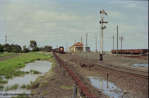 179-05
Gheringhap, yard overview looking east, broad gauge V/Line down goods train 9153 departs for Maroona with the signal on post 4 pulled off for the Maroona line, point rodding and interlocking is spaced away from the line as this location used to have double mainlines, on the right are gypsum waggons in Sidings B.
Keywords: X-class;X53;Clyde-Engineering-Rosewater-SA;EMD;G26C;75-800;