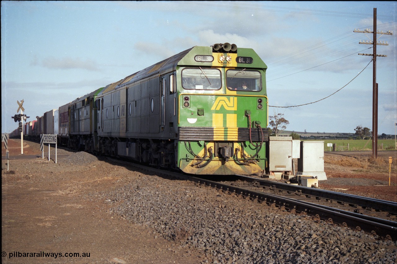 183-06
Rockbank, an Adelaide bound down broad gauge goods train behind Australian National BL class BL 31 Clyde Engineering EMD model JT26C-2SS serial 83-1015 and 700 class 705 AE Goodwin ALCo model DL500G serial G6059-3 at the grade crossing for Station Road.
Keywords: BL-class;BL31;Clyde-Engineering-Rosewater-SA;EMD;JT26C-2SS;83-1015;