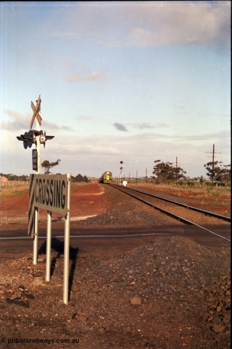 183-04
Rockbank, an Adelaide bound down broad gauge goods train behind Australian National BL class BL 31 Clyde Engineering EMD model JT26C-2SS serial 83-1015 and 700 class 705 AE Goodwin ALCo model DL500G serial G6059-3 climbs the grade as it approaches the grade crossing for Station Road.
