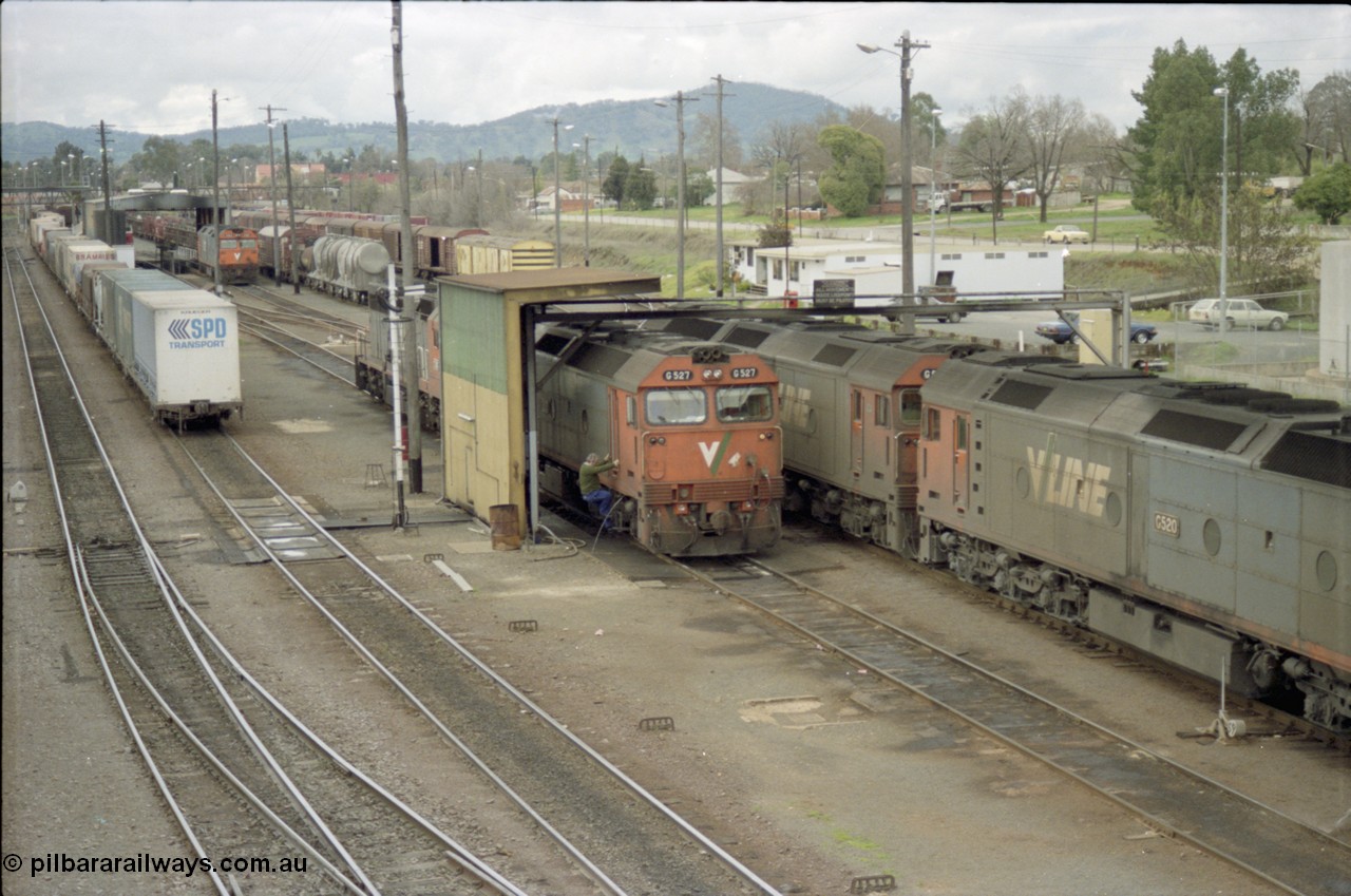 184-22
Albury station yard overview, loco depot, V/Line standard gauge G class G 527 Clyde Engineering EMD model JT26C-2SS serial 88-1257 takes on water at the fuel point with C class behind it while G class G 520 serial 85-1233 leading sister G 525 serial 86-1238 shunts past light engine, elevated view of loco depot and fuel point.
Keywords: G-class;G527;Clyde-Engineering-Somerton-Victoria;EMD;JT26C-2SS;88-1257;C-class;G520;85-1233;G525;86-1238;