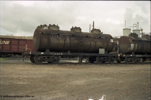 184-04
Albury station yard, broad gauge roads on the west side of the yard, through standard gauge running lines behind, V/Line VTQF type bogie fuel tank waggons VTQF 120 and VTQF 122. Both waggons built new at Newport Workshops as OT type tank waggons in May and March 1929, both to TWF in October 1961, then 120 recoded to VTQY in September 1979 and 122 to VTQY in April 1980, then in 1987/88 VTQY were recoded to VTQF.
Keywords: VTQF-type;VTQF120;VTQF122;TWF-type;Victorian-Railways-Newport-WS;OT-type;