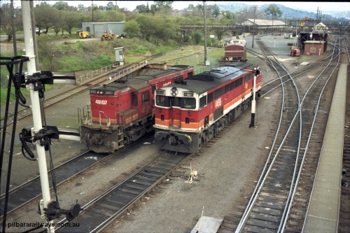 184-25
Albury loco depot, two types of NSWSRA standard gauge ALCo locomotives 48 class 48107 AE Goodwin ALCo model DL531 serial G3420-22 and 44 class 4466 AE Goodwin ALCo model DL500B serial G3421-06 both in candy livery near the loco depot, turntable behind locos, elevated view, semaphore signals, view down yard looking south.
Keywords: 48-class;48107;AE-Goodwin;ALCo;DL531;G3420-22;44-class;4466;DL500B;G3421-6;