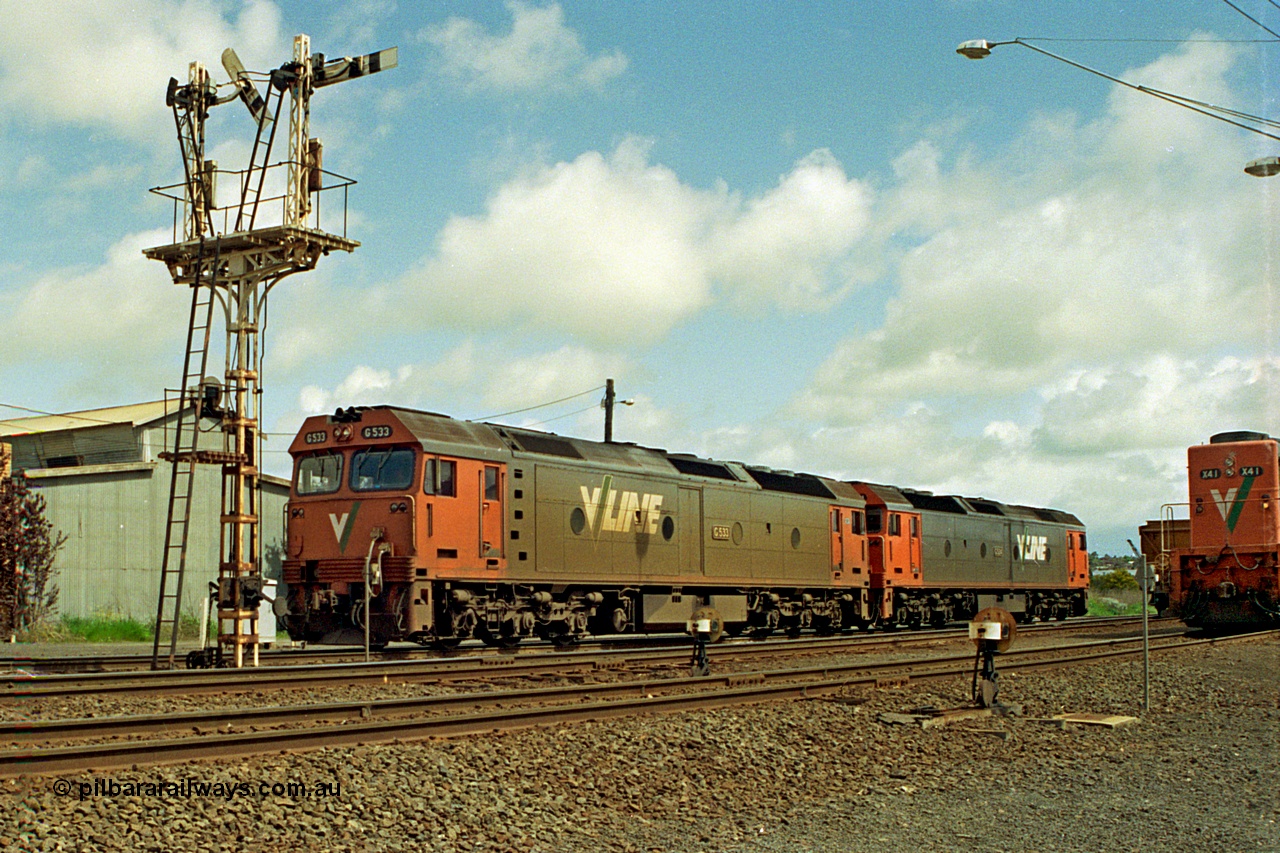 185-01
North Geelong grain arrivals, a pair of V/Line G class locomotives G 533 Clyde Engineering EMD model JT26C-2SS serial 88-1263 and G 524 serial 86-1237 run light engine to Geelong loco depot past semaphore signal post 13 having dropped a loaded grain consist on the arrival road, X class X 44 is on another loaded grain rake.
Keywords: G-class;G533;Clyde-Engineering-Somerton-Victoria;EMD;JT26C-2SS;88-1263;G524;86-1237;